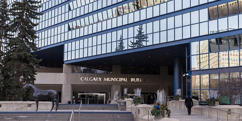 A professional worker installing a large modern window in a residential home.